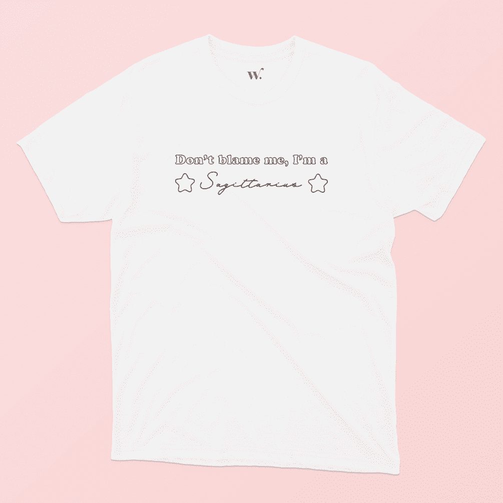 don't blame me I'm a Sagittarius illustrated white t-shirt on a pink background