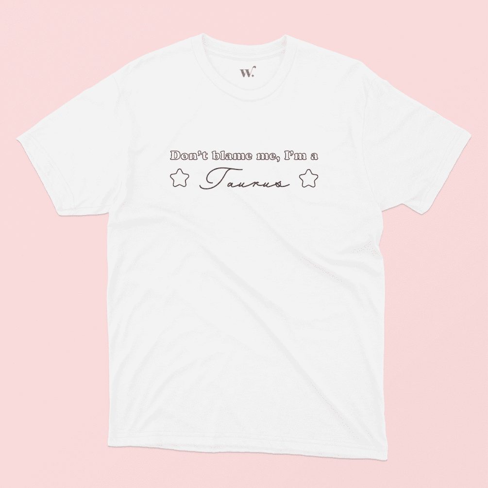 Don't blame me I'm a Taurus illustrated white t-shirt on a pink background