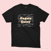 A Black t-shirt with the text "Oopsie Daisy" and an illustrated pattern on a pink background, sold by Willow Designs.